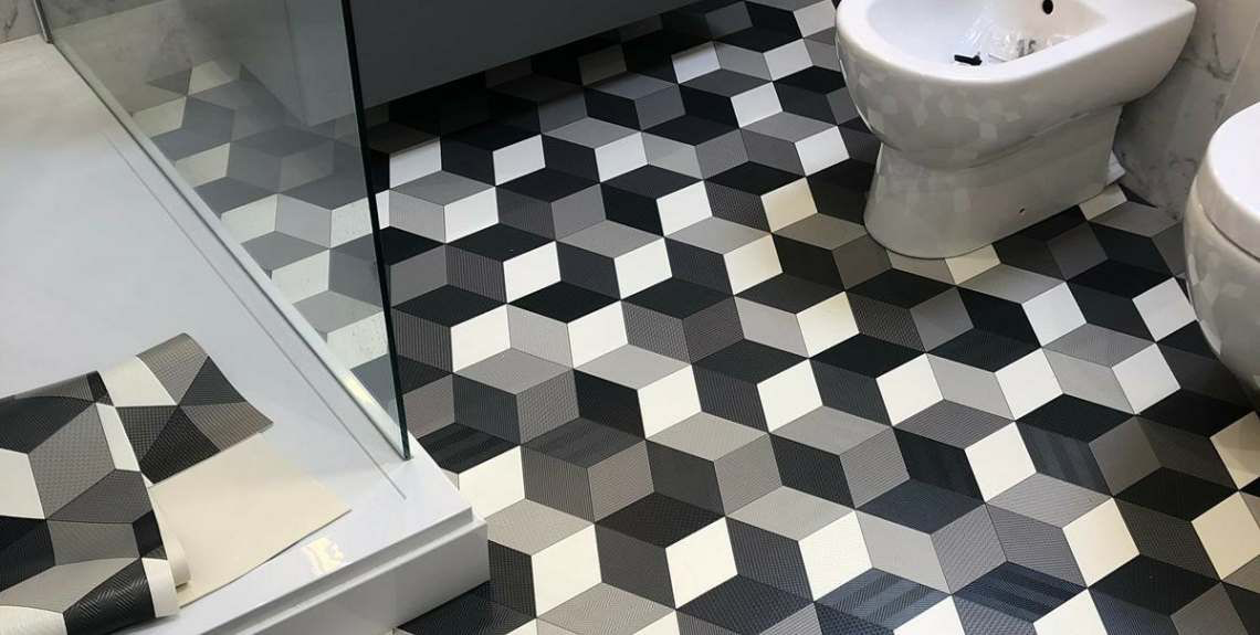 Geometric patterned vinyl fitted in a bathroom, cut around the shower tray and sanitaryware
