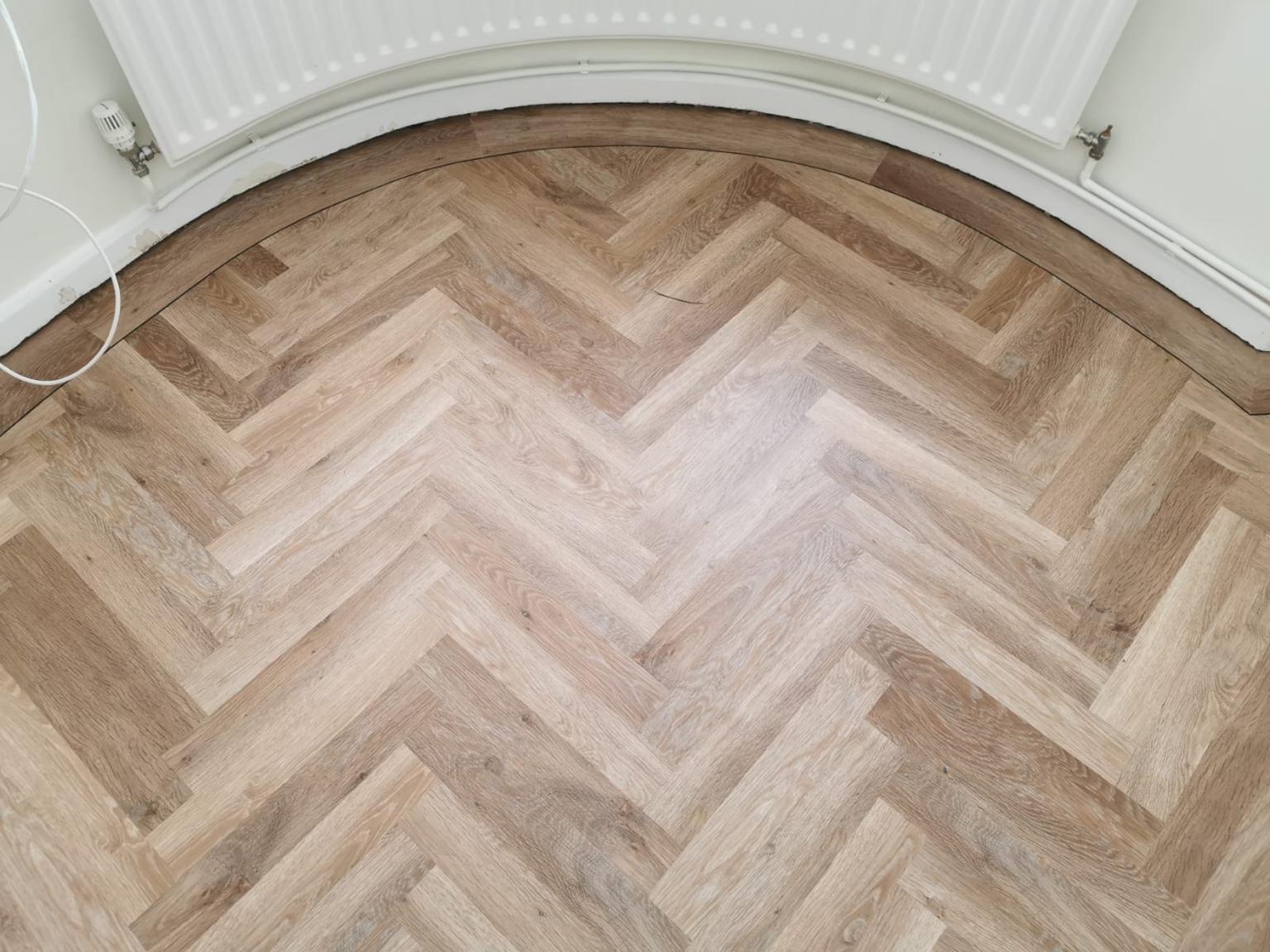 Close detail of the border following the curve of the bay window, each piece cut to the sweep beneath the curved radiator